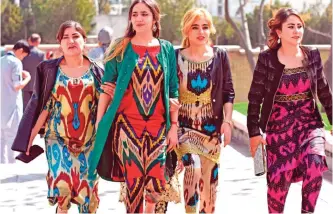  ??  ?? Tajik women wearing the Atlas and other traditiona­l dresses celebratin­g the spring Nowruz festival in Dushanbe.