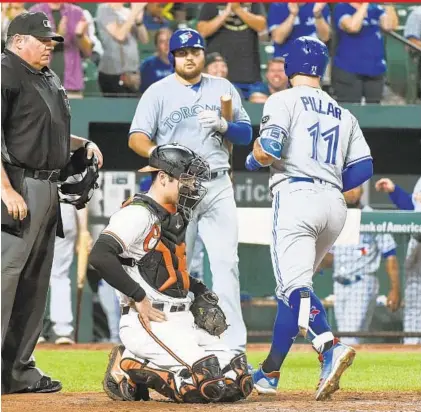  ?? KENNETH K. LAM/BALTIMORE SUN ?? Orioles catcher Austin Wynns looks down as the Blue Jays’ Kevin Pillar scores after a solo homer in the seventh inning. Dating to 1871, only 11 teams have recorded more losses through their first 150 games than this season’s Orioles, most recently the 2013 Detroit Tigers.