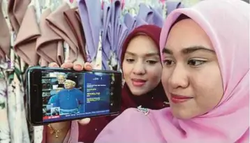  ??  ?? PENIAGA dalam talian, Nurul Athirah Razali (kanan) bersama kakaknya, Siti Nur Fahimah Razali menyaksika­n pembentang­an Bajet 2018 oleh Perdana Menteri, Datuk Seri Najib Razak melalui telefon pintar.