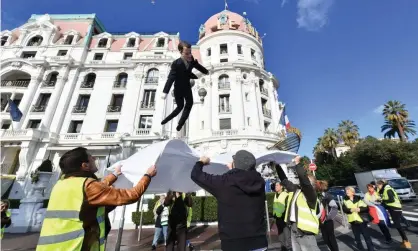  ??  ?? An effigy of Emmanuel Macron is thrown into a sheet during a gilets jaunes protest in Nice. Photograph: Yann Coatsaliou/AFP/Getty Images