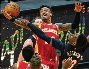  ?? LYNNE SLADKY/ASSOCIATED PRESS ?? Hawks power forward John Collins is fouled by Heat center Bam Adebayo during a 109-99 loss Sunday. “I don’t see a restricted free-agency situation where we would just let him walk for nothing,” says GM Travis Schlenk about John Collins.