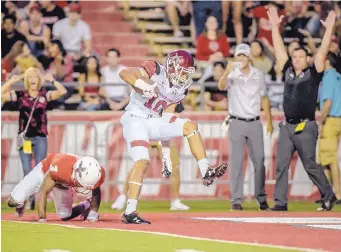  ?? ROBERTO E. ROSALES/JOURNAL ?? New Mexico State wide reciever Izaiah Lottie (10) steps over UNM defender D’Angelo Ross during the Aggies’ victory earlier this month. Lottie ranks second nationally in yards per reception.