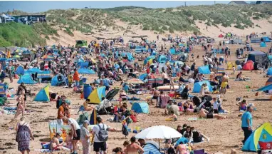  ?? MARK LEWIS ?? Visitors enjoy the sunshine at Coney Beach in Porthcawl yesterday