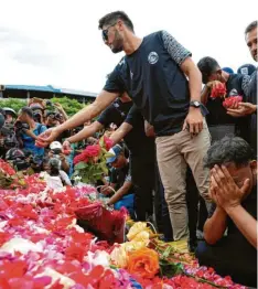  ?? Foto: Achmad Ibrahim/AP, dpa ?? Am Tag nach der Tragödie beten Spieler und Funktionär­e des Fußballver­eins Arema FC vor dem Kanjuruhan-Stadion.