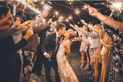  ?? ?? Isaac and Carla Knight enter their wedding dance through a sparkler tunnel.