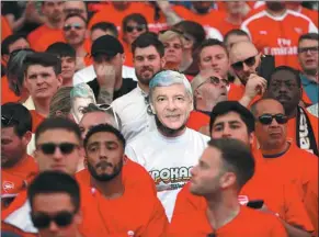  ?? IAN WALTON / REUTERS ?? waves to the crowd after his final home match as Arsenal manager on Sunday. Right: A fan wears a Wenger mask while watching the Gunners whip Burnley 5-0 at Emirates Stadium.