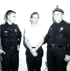  ??  ?? Oswald is pictured with Dallas police Sgt. Warren (right) and a fellow officer in Dallas, in this handout image taken on Nov 22, 1963. — Reuters photos