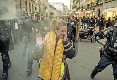  ??  ?? A Parigi la polizia disperde il blocco stradale dei manifestan­ti con i giubbotti gialli, simbolo della protesta contro l’aumento dei prezzi dei carburanti