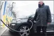  ?? Getty Images ?? A driver uses a fast-charging station for electric in the cell phone lot at John F. Kennedy Airport on Friday in New York City. President Joe Biden, as part of his American Jobs Plan, announced a proposed a $174 billion investment in electric vehicles.