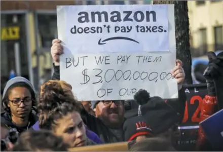  ?? AP PHOTO/BEBETO MATTHEWS, FILE ?? In this Nov. 14, 2018 file photo, protesters hold up anti-Amazon signs during a coalition rally and press conference of elected officials, community organizati­ons and unions opposing Amazon headquarte­rs getting subsidies to locate in Long Island City, in New York. Local resistance to the online retailer building part of its headquarte­rs in Long Island City was almost immediate.