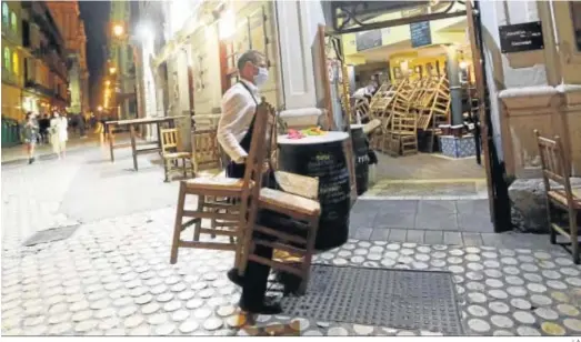  ?? J. A. ?? Un camarero recoge las sillas y mesas en un bar del centro de Málaga.