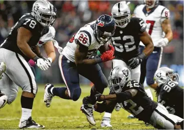  ?? Brett Coomer / Houston Chronicle ?? Lamar Miller (centro), running back de los Texans, es detenido por Karl Joseph, de los Raiders de Oakland, durante el partido de la NFL disputado el martes 21 de noviembre en el estadio Azteca de México.