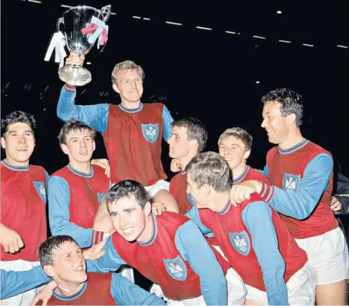  ?? ?? Happy days: West Ham players carry captain Bobby Moore with the Cup Winners’ Cup after their triumph at Wembley in 1965 (left); Alan Sealey opens the scoring against 1860 Munich (below, right); and Brian Dear at a Premier League match in 2019 (below, left)