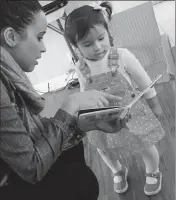  ?? ASSOCIATED PRESS ?? IN THIS 2016 PHOTO, caseworker Stephanie Taveras (left) reads a book with 20-month-old Gracey Niebla at the child’s home in Providence, R.I.