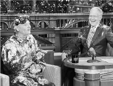  ?? John Paul Filo / CBS viaThe Associate d Pres ?? Actor Bill Murray, left, talks with host David Letterman after emerging from a cake to say goodbye on Tuesday. Letterman’s final show aired Wednesday.