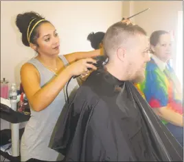  ??  ?? Nicole Quiros, a hair stylist at Feli’s Salon & Spa, gives La Plata resident Joseph Garner a hair cut at Community Resource Day at the Waldorf Jaycees on Oct. 5.