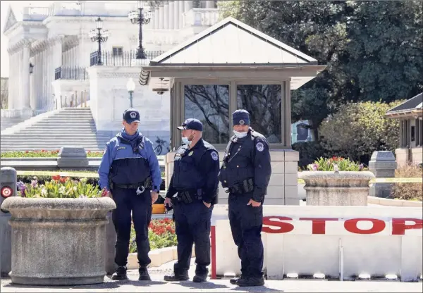  ?? Saul Loeb / Getty Images ?? U.S. Capitol police officers Saturday pause to pay their respects at the Capitol location where fellow officer William Evans was killed Friday after a vehicle driven by suspect Noah Green rammed through security and crashed into a barrier. Capitol Police shot and killed Green after he lunged at police with a knife.