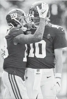  ?? GRANT HALVERSON GETTY IMAGES ?? Odell Beckham Jr. , left, thanks QB Eli Manning of the N.Y. Giants for a touchdown pass against the Carolina Panthers in the fourth quarter. The Giants sunk to 1-4 on the season, losing to the Panthers, 33-31.