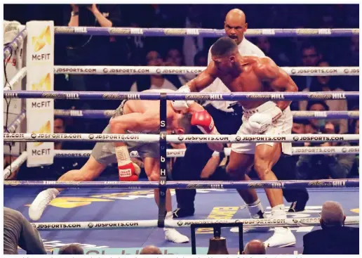  ??  ?? British boxer Anthony Joshua, right, knocks down Ukrainian boxer Wladimir Klitschko as they fight for Joshua's IBF and the vacant WBA Super World and IBO heavyweigh­t titles at Wembley stadium in London Saturday. Joshua won with an 11th round stoppage....
