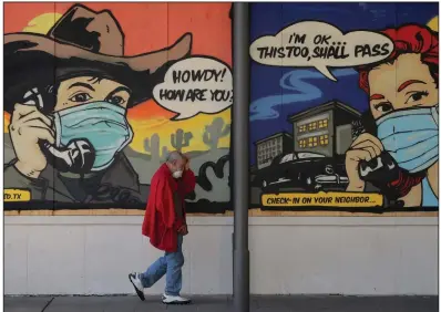  ?? (AP/Eric Gay) ?? A pedestrian on Monday passes a mural painted on a boarded-up business in Austin, Texas, that closed because of the coronaviru­s pandemic.