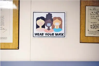  ?? BRIANNA PACIORKA/NEWS SENTINEL ?? A “Wear your mask” sign hangs inside Gresham Middle School in Knoxville last week.