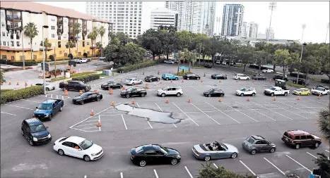  ?? OCTAVIO JONES/GETTY ?? Motorists wait to enter a drive-thru testing site Wednesday in St. Petersburg, Florida. The positive test rate has ballooned in several states.