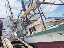  ?? [AP PHOTO] ?? A shrimp boat is sunk at its mooring along the Pascagoula River in Moss Point, Miss., on Sunday after Hurricane Nate made landfall on Mississipp­i’s Gulf Coast.