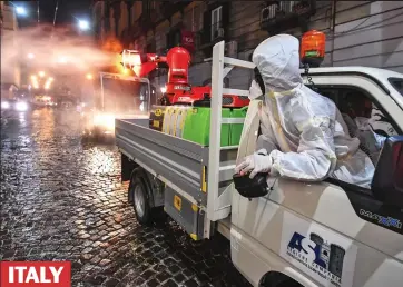  ??  ?? ITALY Spraying for a miracle: Workers in hazmat suits disinfect streets in Naples