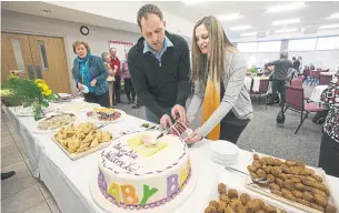  ?? BERNARD WEIL/TORONTO STAR ?? Stouffvill­e Mayor Justin Altmann and his wife, Jenny, cut a cake during a baby shower Sunday.