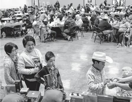  ?? Photos by Sam Owens/staff photograph­er ?? Children wait in line to receive free treats and stuffed animals while attending the 39th annual Luv Ya Uvalde Thanksgivi­ng meal.