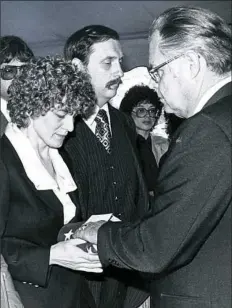  ??  ?? Mary Ann Adams receives the flag that draped her husband’s coffin.