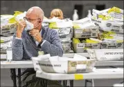  ?? ALYSSA POINTER / ALYSSA.POINTER@AJC.COM ?? Mail-in paper ballots wait to be scanned by Fulton County employees at the Georgia World Congress Center during the Georgia primary. Voters will soon be able to request ballots online.