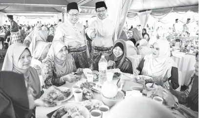  ?? — Gambar Bernama ?? RUMAH TERBUKA: Nawawi (berdiri kiri) dan Ketua Pegawai Eksekutif KTMB Mohd Rani Hisham Samsudin (berdiri kanan) beramah mesra dengan warga KTMB yang hadir pada Majlis Rumah Terbuka Hari Raya Anjuran KTMB di Kuala Lumpur semalam.