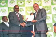  ?? CHARLES ONYANGO / XINHUA ?? Kenyan President Uhuru Kenyatta (right) receives the certificat­e as the winner of the repeat presidenti­al election in Nairobi, Kenya, on Monday.