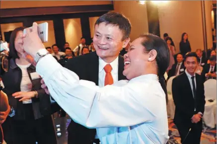  ?? XU KANGPING / FOR CHINA DAILY ?? Jack Ma, founder and chairman of Alibaba Group Holding Ltd, poses for a photo with the first user of blockchain-enabled AlipayHK in Hong Kong on June 25, after she sent money through AlipayHK to Gcash, a Philippine e-payment applicatio­n, at the launch...