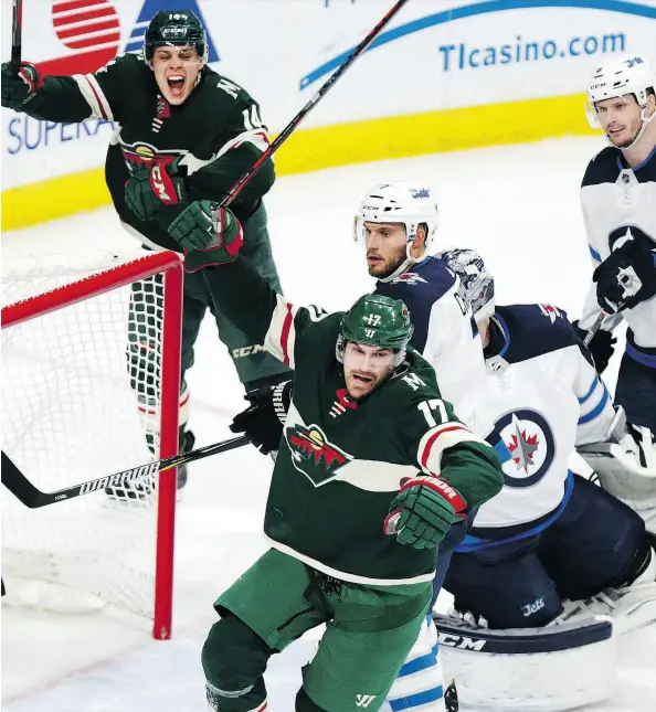  ?? ANDY CLAYTON-KING/THE ASSOCIATED PRESS ?? Minnesota Wild winger Marcus Foligno, bottom, and centreman Joel Eriksson Ek celebrate after Foligno scored a goal on Winnipeg Jets goaltender Connor Hellebuyck in the second period of Game 3 on Sunday in St. Paul, Minn.