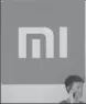  ?? REUTERS ?? A man uses a mobile phone in front of the logo of Xiaomi in Beijing.