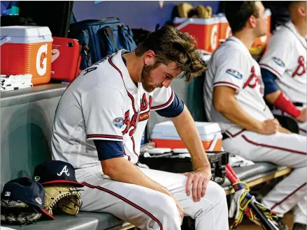  ?? CURTIS COMPTON / CCOMPTON@AJC.COM ?? Braves relief pitcher Chad Sobotka sits in the dugout Monday with his head down after giving up a three-run homer to the Dodgers’ Manny Machado. Sobotka, who joined the majors in August, was Atlanta’s fifth pitcher of the game.