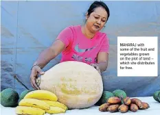  ??  ?? MAHARAJ with some of the fruit and vegetables grown on the plot of land – which she distribute­s for free.