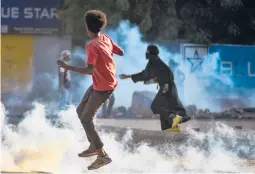  ?? GETTY-AFP ?? Sudanese youths confront security forces using tear gas to disperse protesters Wednesday in Khartoum, the capital, amid ongoing pro-democracy demonstrat­ions.