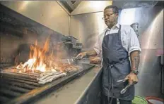  ?? Andrew Rush/Post-Gazette ?? Grill master Courtney McFarlane grills burgers in the kitchen at Tessaro's in Bloomfield.