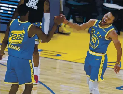  ?? PHOTOS BY TONY AVELAR — THE ASSOCIATED PRESS ?? The Warriors’ Andrew Wiggins (22) celebrates with Stephen Curry after Wiggins made a 3-point shot against the Clippers on Friday.