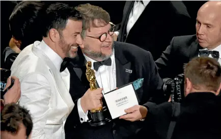  ?? PHOTO: AP ?? Jimmy Kimmel, left, congratula­tes Guillermo del Toro after del Toro won the award for best picture for The Shape of Water at the Oscars yesterday at the Dolby Theatre in Los Angeles.