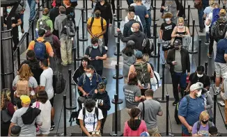  ?? DAVID ZALUBOWSKI/AP ?? Travelers line up at a security checkpoint at Denver Internatio­nal Airport. New policies announced by the Biden administra­tion will affect people entering the U.S. more than those departing.