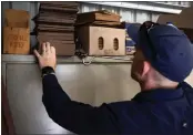  ?? DAVID MAURICE SMITH — THE NEW YORK TIMES ?? Stuart McKenzie, who runs a snake-catching service, removes a python from a storage shed at a high school.