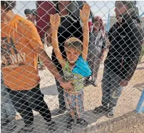  ?? AFP ?? Displaced Syrians queue up to receive food at Al Mabrouka camp in the village of Ras Al Ain on the Syria-Turkey border, where many Syrians are taking shelter. —