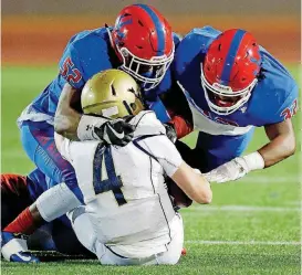  ?? [PHOTO BY NATE BILLINGS, THE OKLAHOMAN] ?? John Marshall’s Javier Morales, left, and Alonzo Cole bring down Kingfisher quarterbac­k Jett Sternberge­r in a 3A playoff game last month.