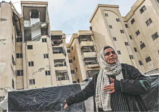  ?? Said Khatib / AFP ?? A woman outside a damaged building following Israeli bombings in Rafah.
