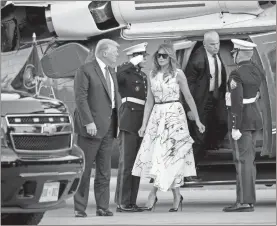  ?? AP-Alex Brandon, File ?? President Donald Trump, accompanie­d by first lady Melania Trump, step off Marine One as they arrive at Mount Rushmore National Memorial near Keystone, S.D. The Associated Press reported on stories circulatin­g online incorrectl­y asserting the dress Melania Trump wore during Fourth of July celebratio­ns featured drawings by various victims of child sex traffickin­g. The sketches on the dress were made by design students from the British art school Central Saint Martins.