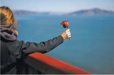  ?? Photos by Mason Trinca / Special to The Chronicle ?? Above: Kymberlyre­nee Gamboa prepares to toss a rose over the side of the Golden Gate Bridge at 11:45 a.m. on Sept. 20, the moment in 2013 her son Kyle jumped. Below: A memorial to Kyle.